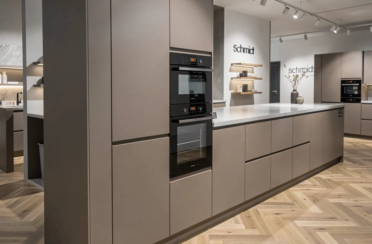 Cuisine haut de gamme en laque taupe ultra-mat avec tour colonne four et plan de travail en Dekton dans le showroom Schmidt d'Arras